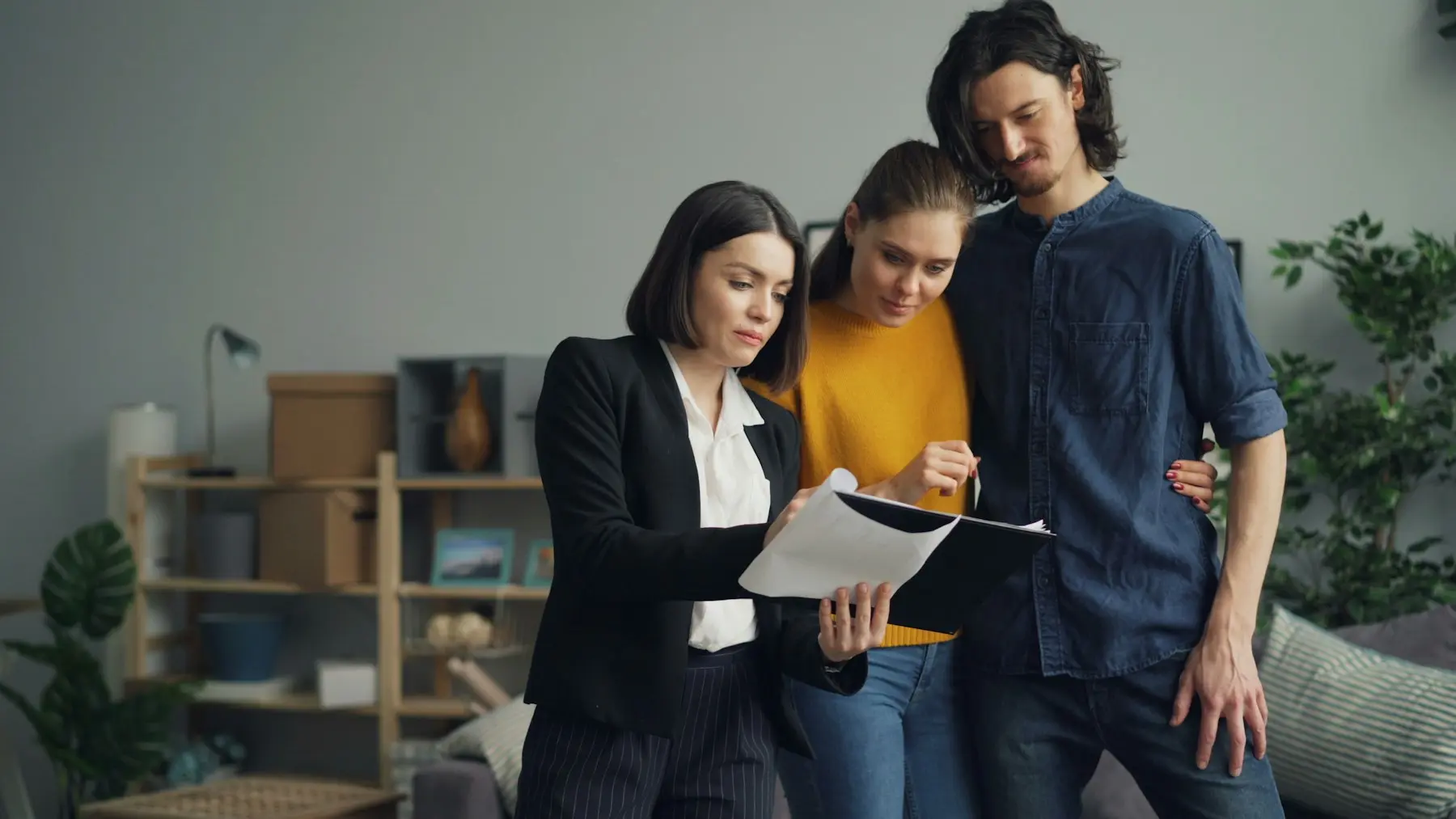 Agent walking clients through the paperwork in a living room